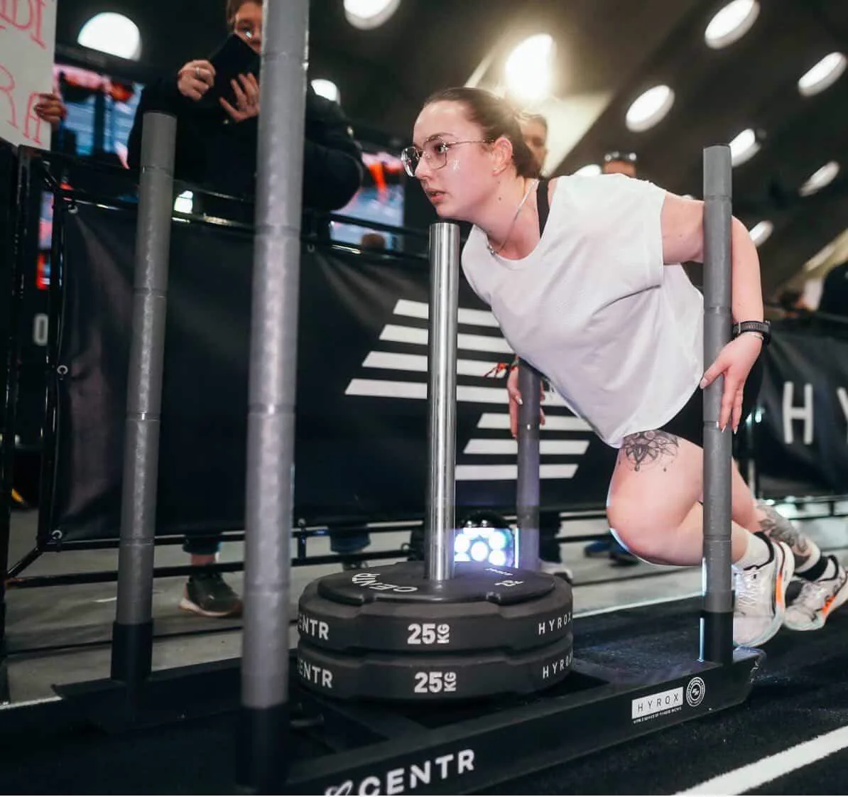 Athlète BodyMind pendant une poussée de traîneau lors d'un HYROX
